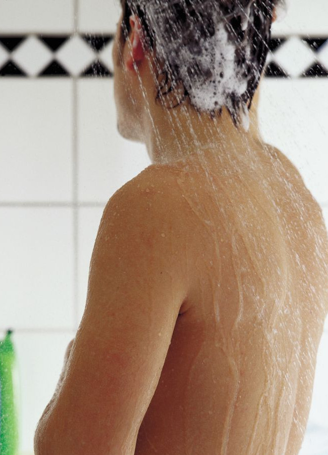 Mann steht unter der Dusche